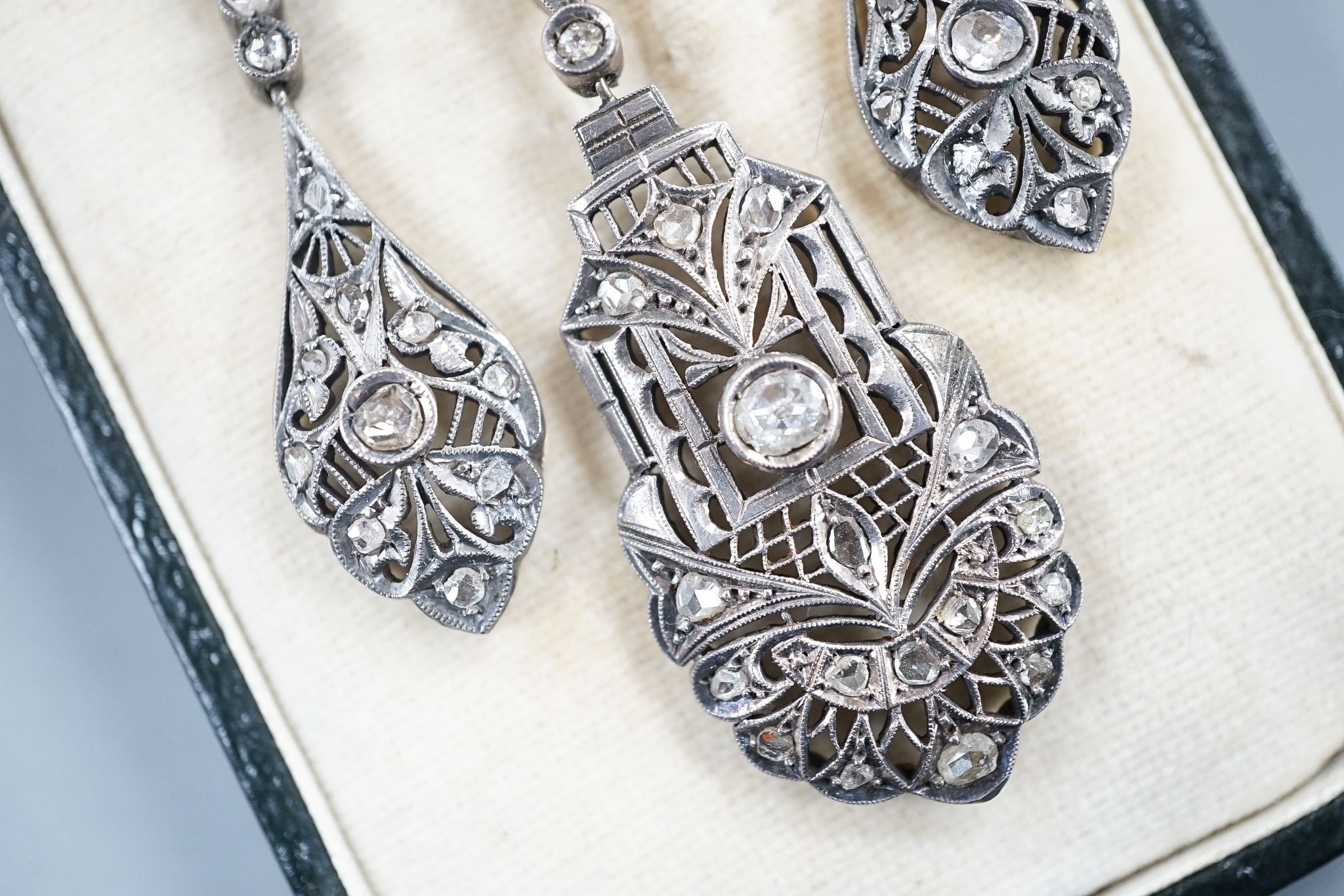 A 19th century pierced white and yellow metal and rose cut diamond set suite of jewellery, comprising a pendant 48mm and a pair of matching drop earrings, gross weight 11.2 grams.